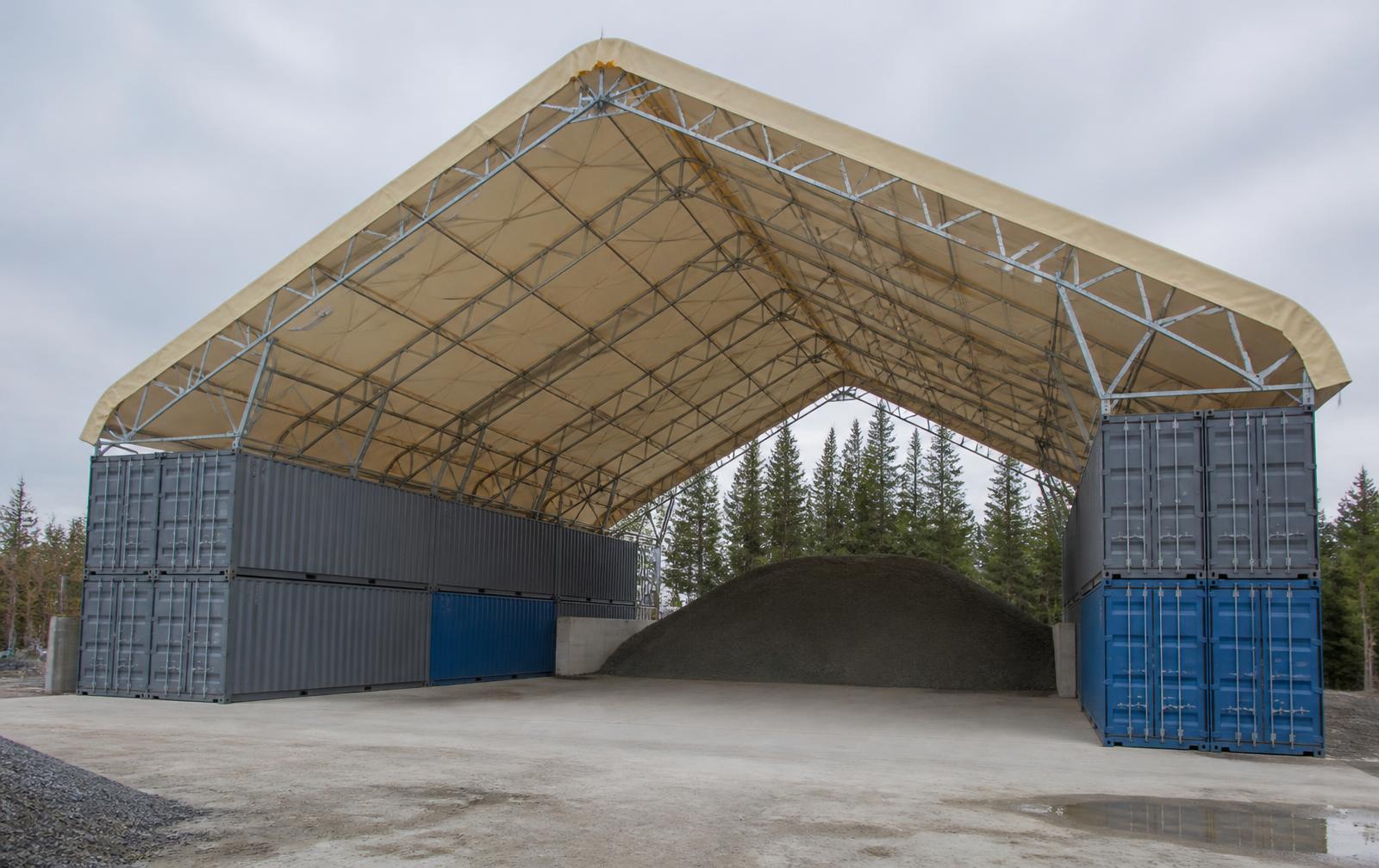 Interior of a MegaDome container-mounted fabric roof spanning between two rows of shipping containers in Ontario